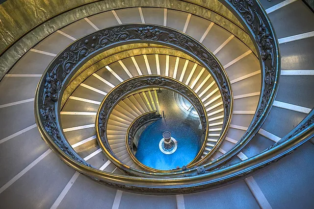 The double spiral staircase of the Vatican Museums designed by Giuseppe Momo, seen from below with its curving ironwork railing